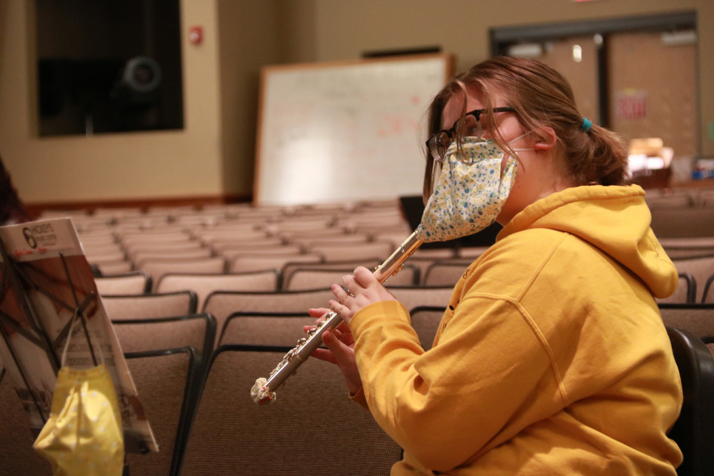 student wearing mask playing flute