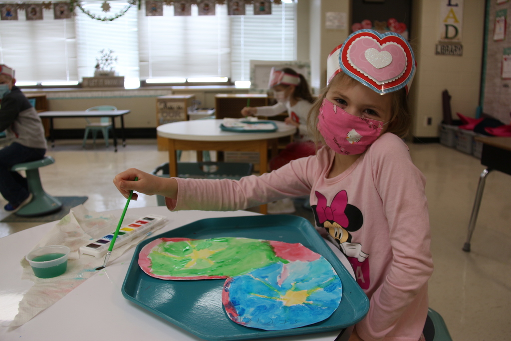student painting a heart