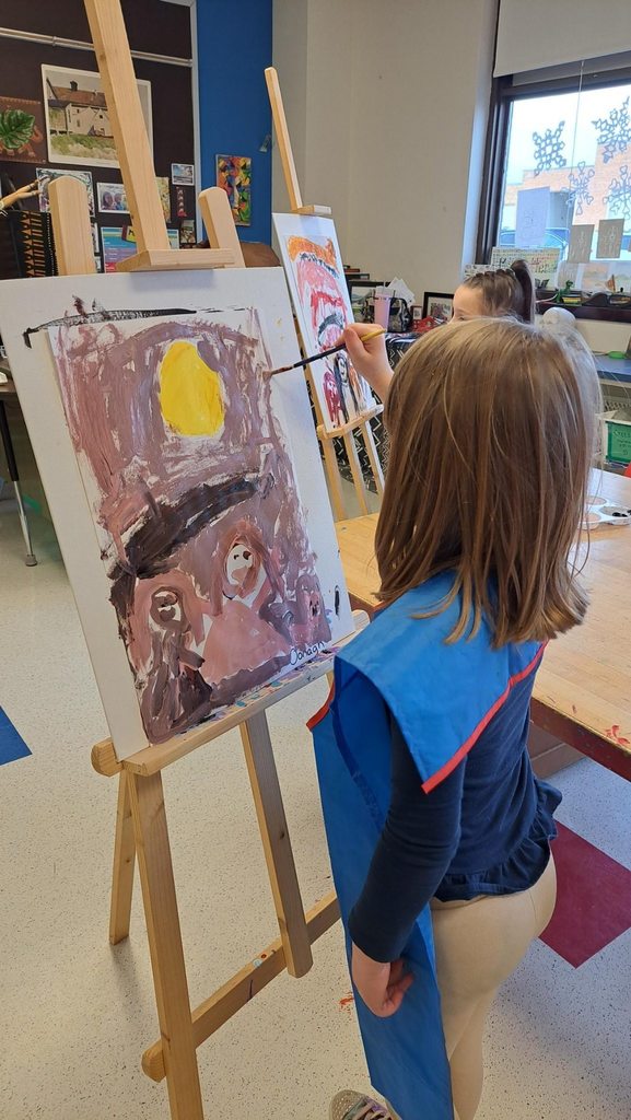 Kindergarteners focused on their paintings and mixing warm colors. 