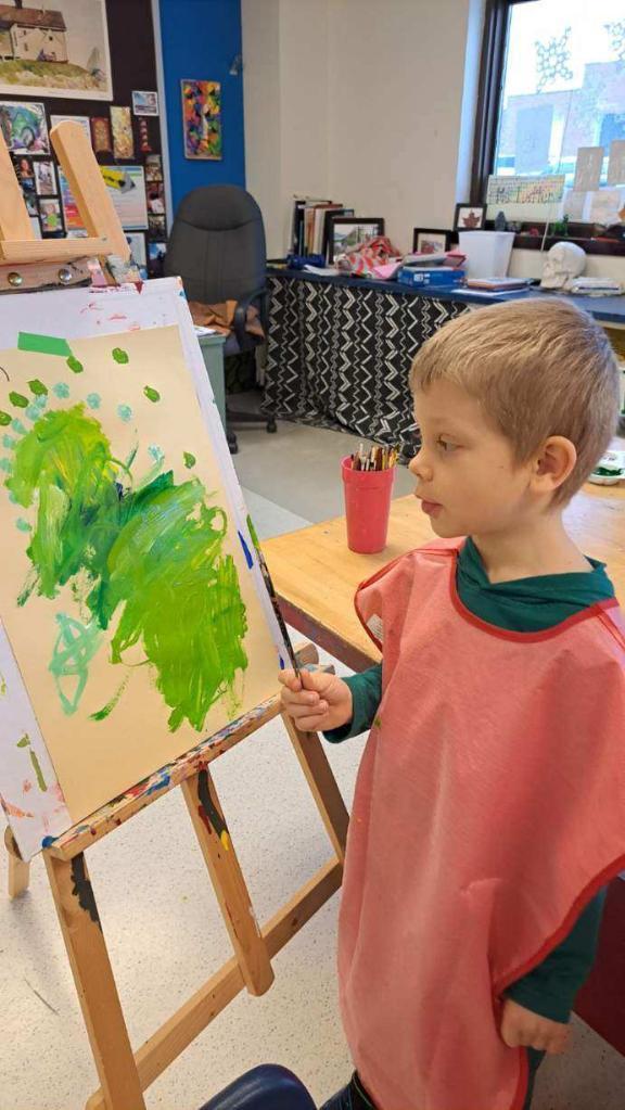 Kindergarteners focused on their paintings