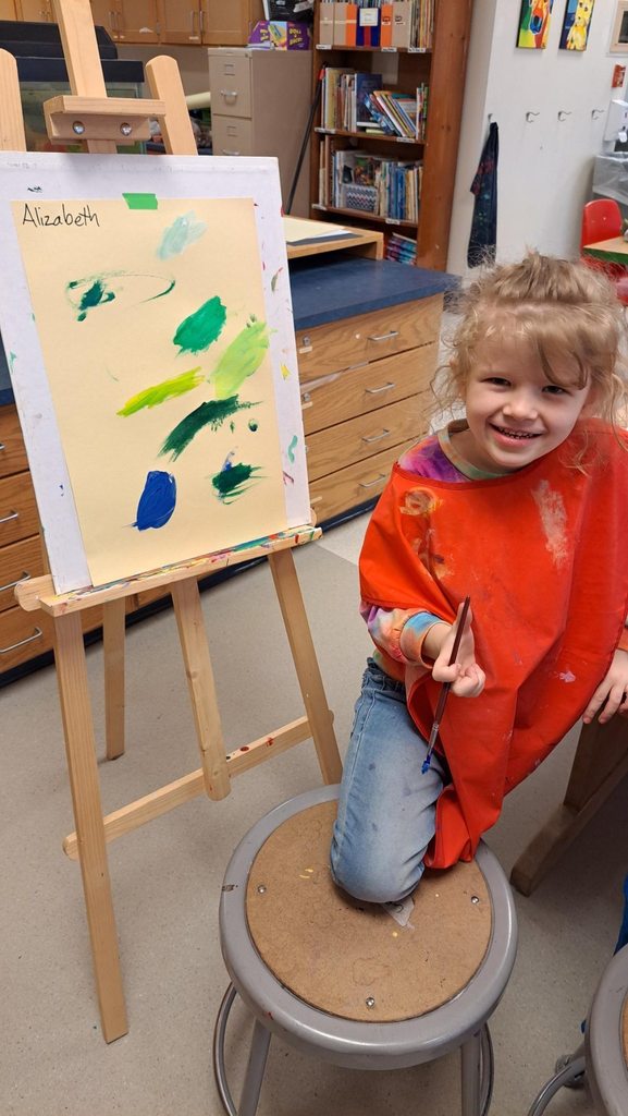 Kindergarteners focused on their paintings 
